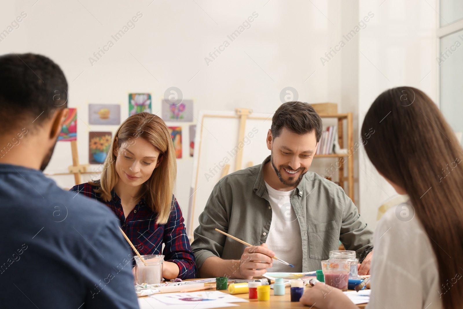Photo of Group of students attending painting class in studio. Creative hobby