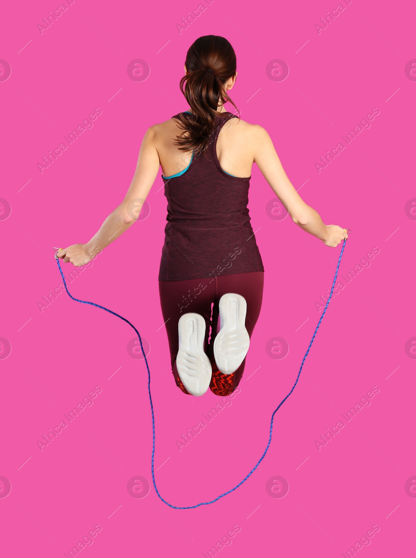 Photo of Sportive woman training with jump rope on color background