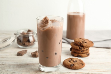 Photo of Glass with tasty chocolate milk on wooden table. Dairy drink