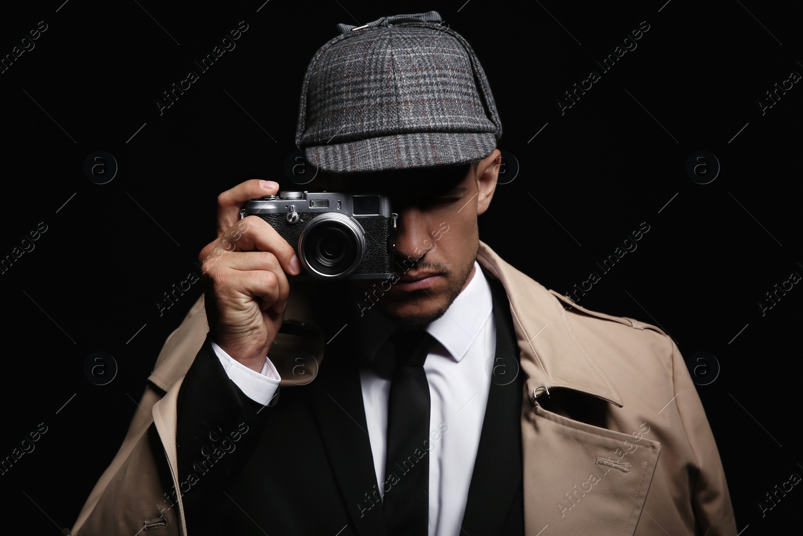 Photo of Old fashioned detective with camera on dark background