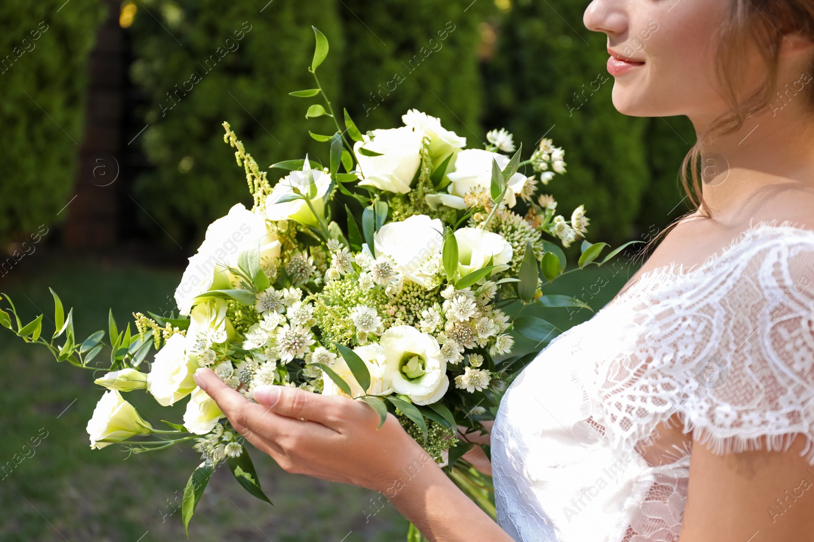 Photo of Bride in beautiful wedding dress with bouquet outdoors, closeup