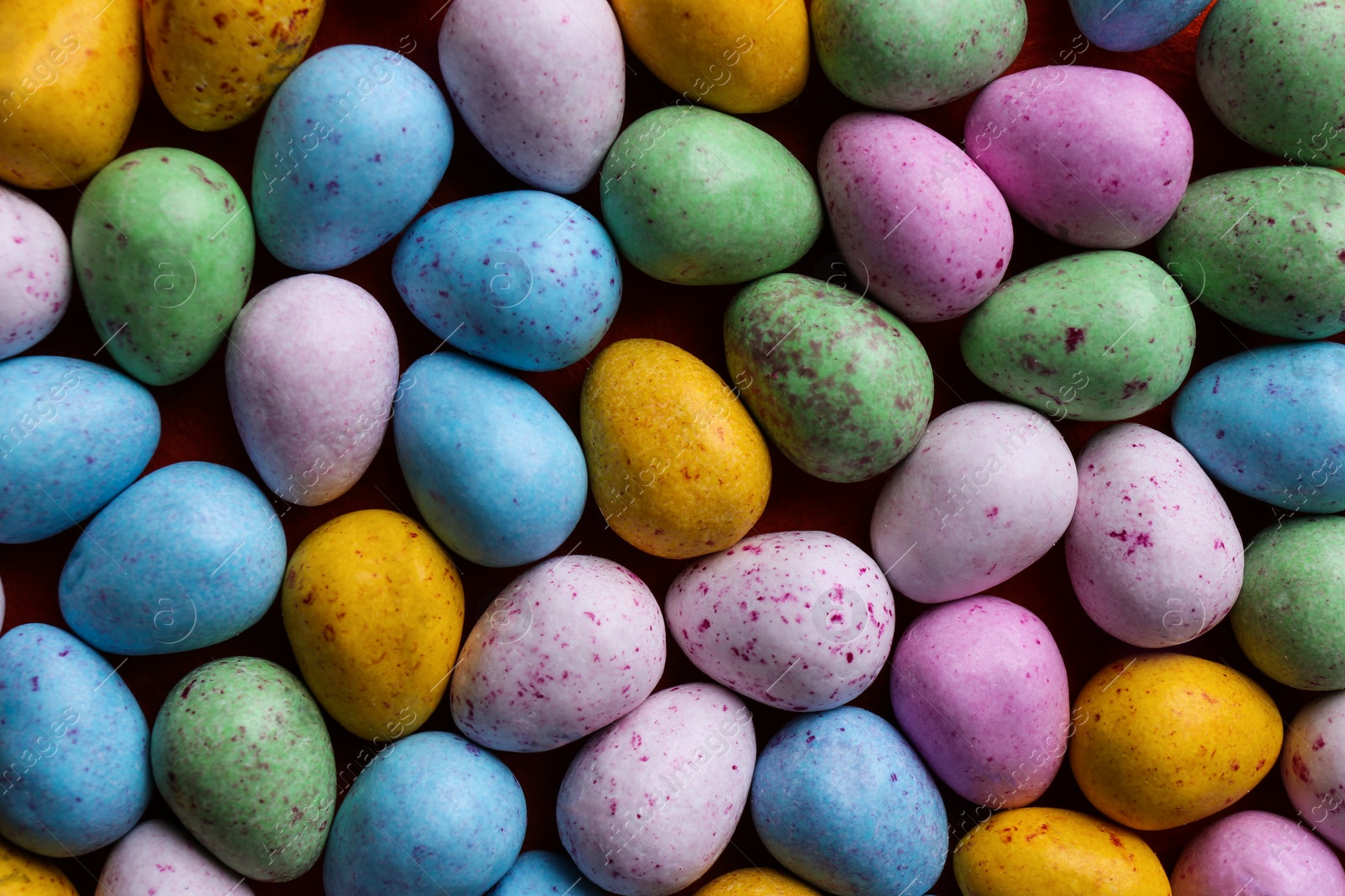 Photo of Many delicious colorful dragee candies as background, top view