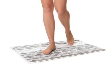 Photo of Woman standing on stylish bath mat against white background, closeup