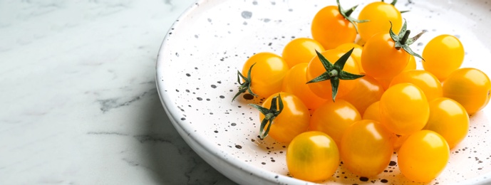 Photo of Ripe yellow tomatoes on white marble table, closeup