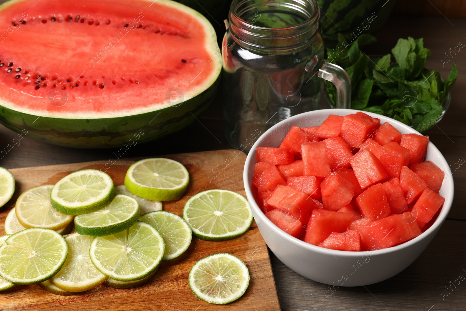 Photo of Fresh ingredients for making watermelon drink with lime on wooden table