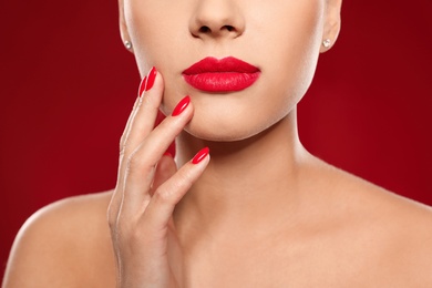 Photo of Beautiful young woman with bright manicure on color background, closeup. Nail polish trends