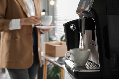 Photo of Preparing fresh aromatic coffee with modern machine in office, closeup. Space for text