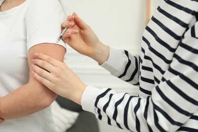 Photo of Diabetes. Woman getting insulin injection indoors, closeup