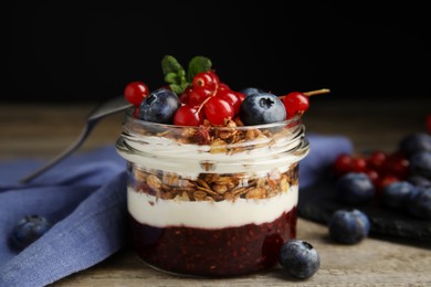 Photo of Delicious yogurt parfait with fresh berries and mint on wooden table, closeup