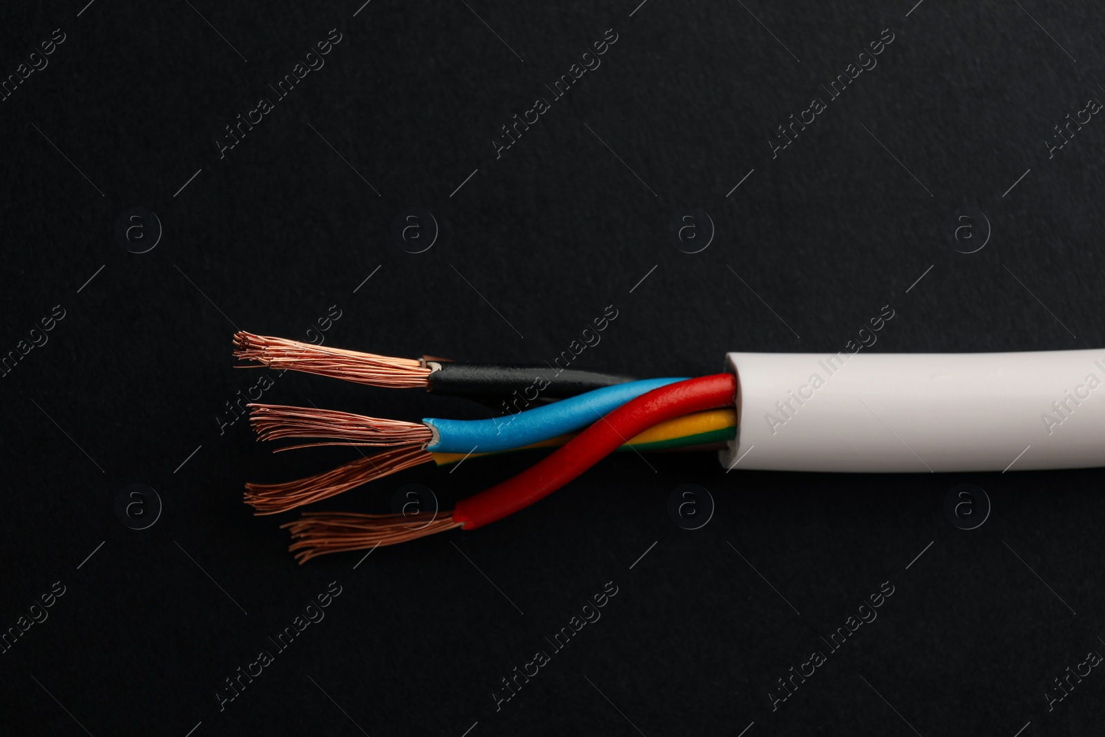 Photo of Cable with stripped wires on black background, closeup