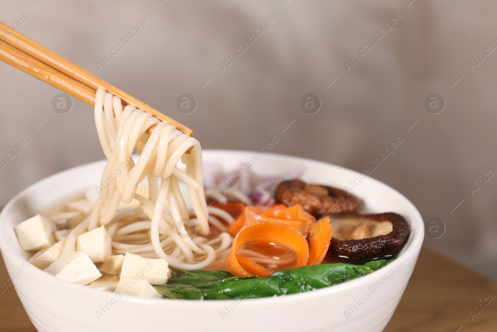 Photo of Eating delicious vegetarian ramen at table, space for text. Noodle soup