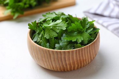 Photo of Fresh green parsley in wooden bowl on white table