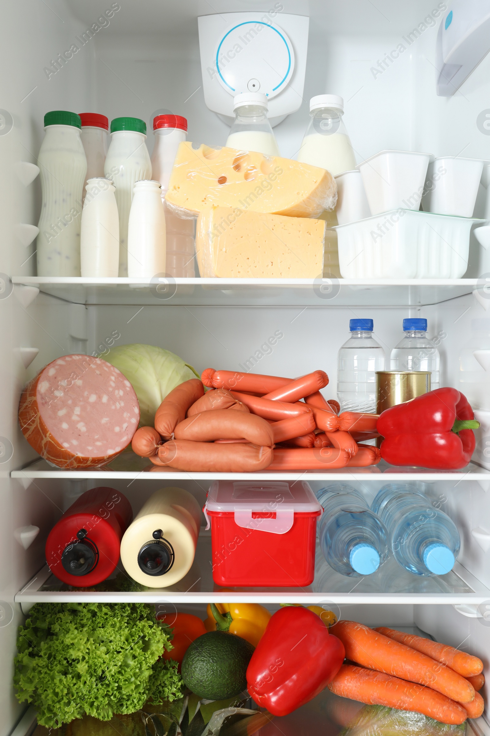 Photo of Open refrigerator with many different products, closeup