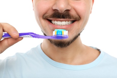 Photo of Young man brushing teeth on white background, closeup