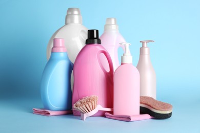 Photo of Different cleaning supplies and tools on light blue background