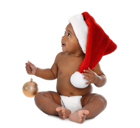 Cute African-American baby wearing Santa hat with Christmas decoration on white background