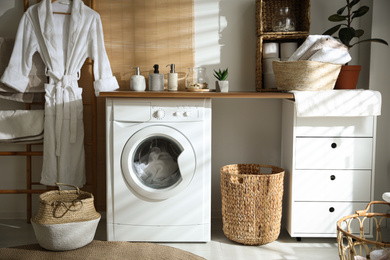 Photo of Stylish bathroom interior with modern washing machine