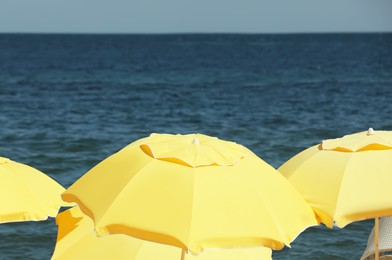 Photo of Yellow beach umbrellas near sea on sunny day
