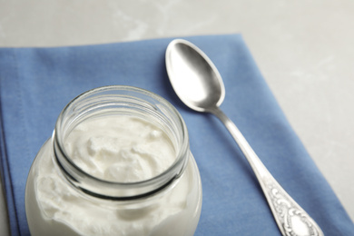 Photo of Tasty organic yogurt in glass jar, closeup. Space for text