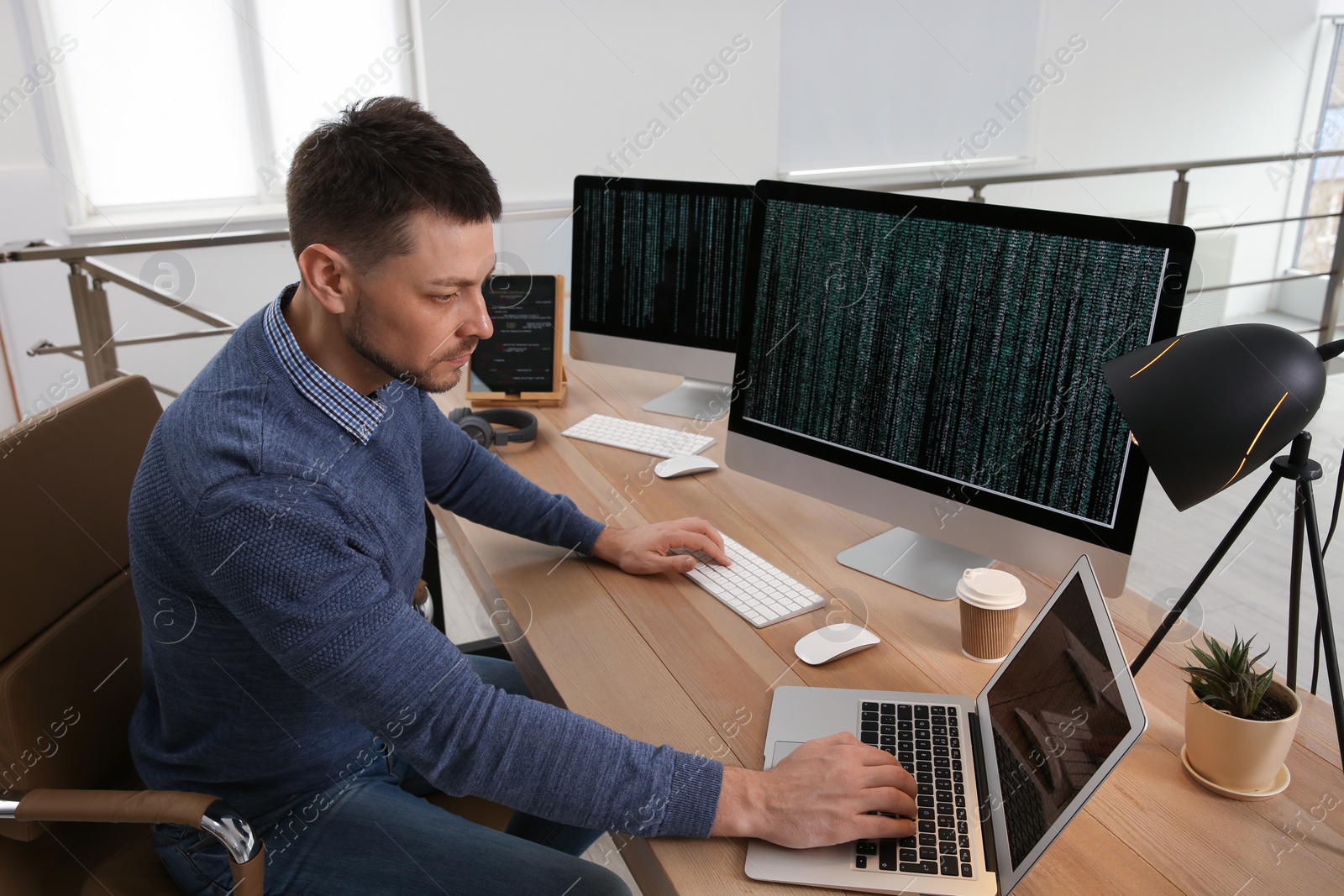 Photo of Programmer working at desk in modern office