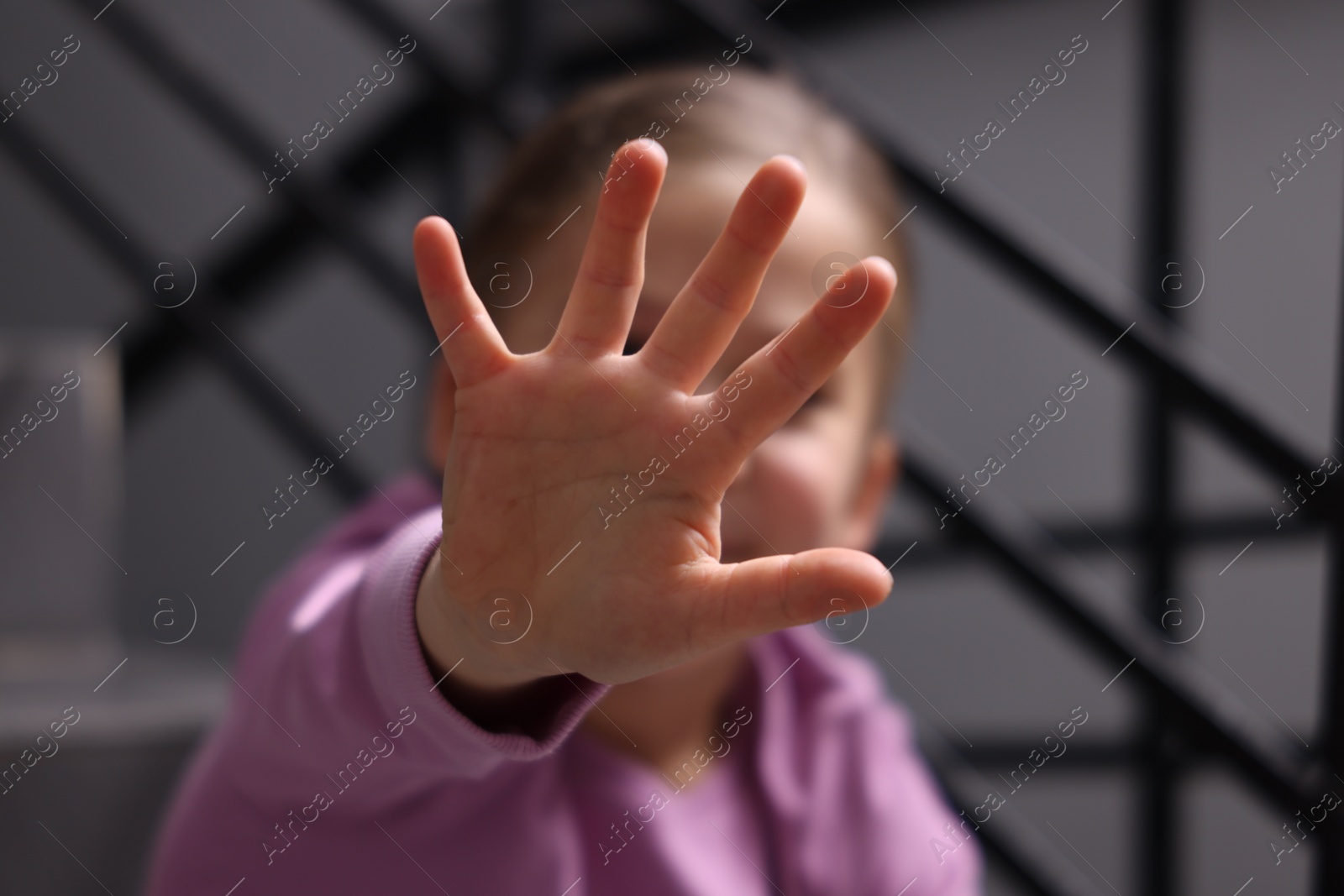 Photo of Child abuse. Girl making stop gesture sitting on stairs, selective focus