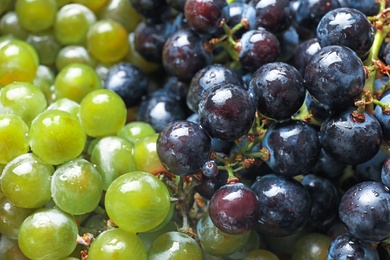 Photo of Fresh ripe juicy grapes with water drops as background, closeup