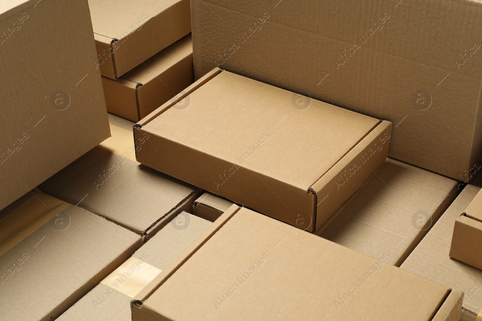 Photo of Many cardboard boxes as background, closeup. Packaging goods