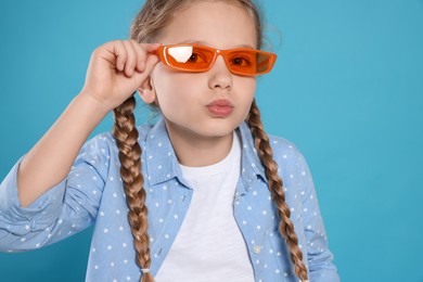 Photo of Girl in orange sunglasses on light blue background