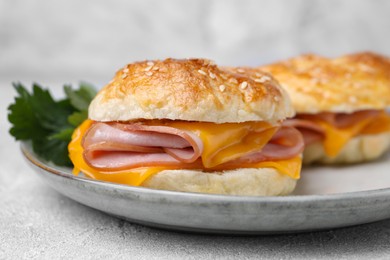 Photo of Delicious bagels with ham and cheese on table, closeup