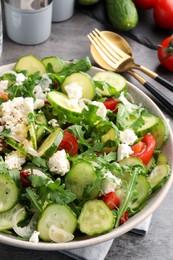 Photo of Plate of delicious cucumber salad served on grey table, closeup