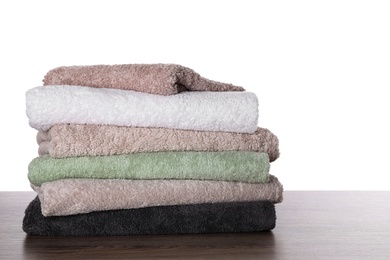 Stacked soft towels on table against white background