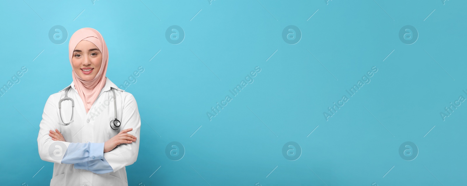 Image of Muslim woman in hijab and medical uniform with stethoscope on light blue background, space for text. Banner design