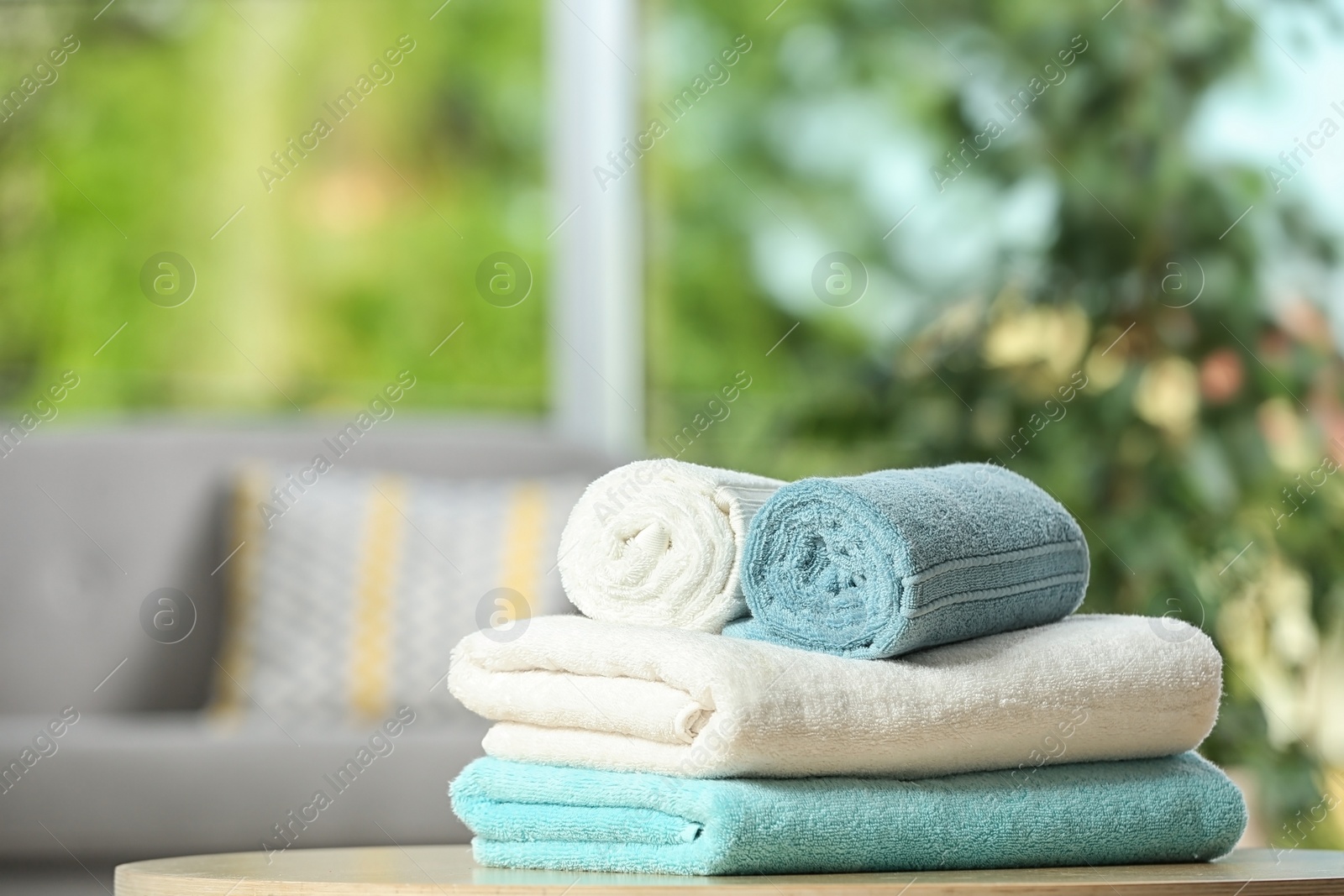 Photo of Clean soft terry towels on table indoors. Space for text