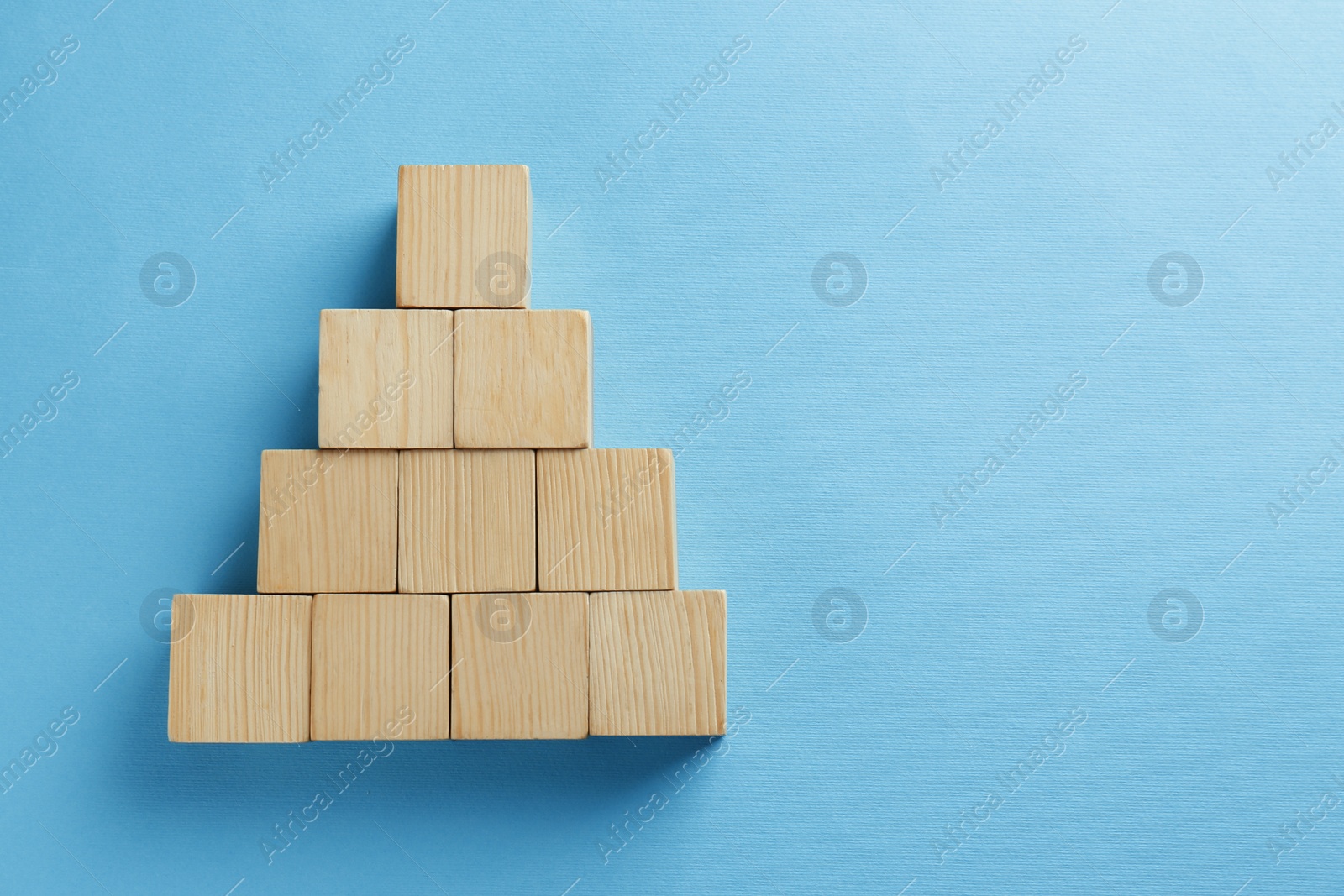 Photo of Blank wooden cubes on light blue background, flat lay. Space for text