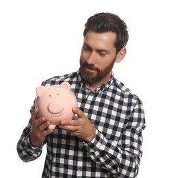 Happy man with ceramic piggy bank on white background
