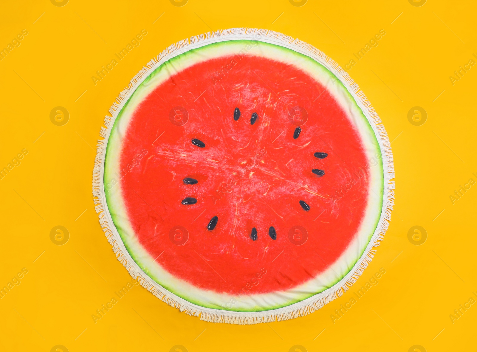 Photo of Round watermelon beach towel on yellow background, top view