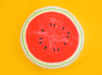 Round watermelon beach towel on yellow background, top view