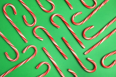 Flat lay composition with tasty candy canes on color background