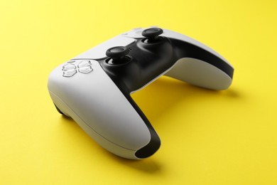 Photo of One wireless game controller on yellow background, closeup