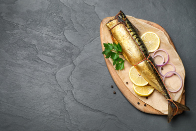 Photo of Tasty smoked fish on black table, top view. Space for text
