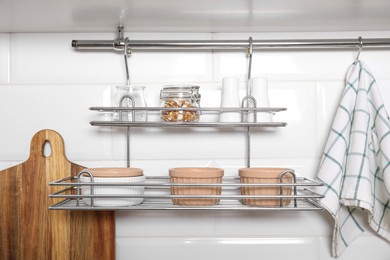 Photo of Kitchen towel hanging on hook rod and shelves with ramekins indoors