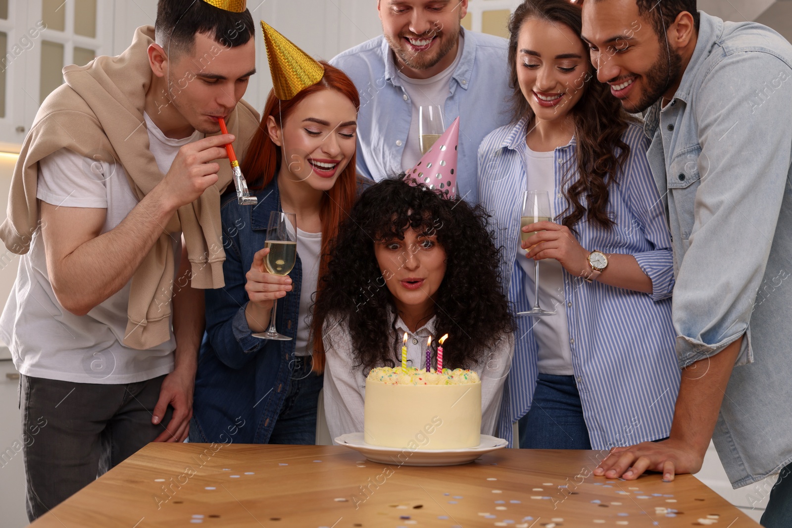 Photo of Happy friends with tasty cake celebrating birthday indoors