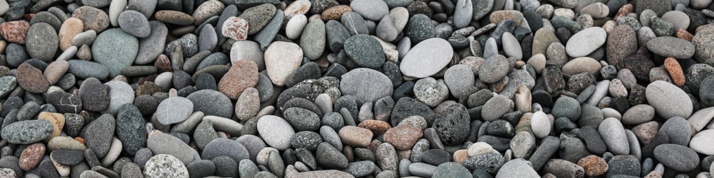 Many different pebbles as background, top view. Banner design