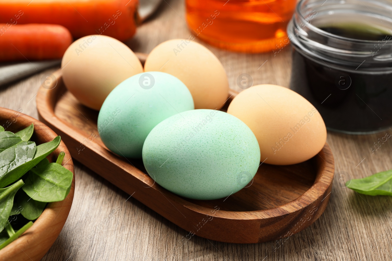 Photo of Naturally painted Easter eggs on wooden table, closeup. Spinach used for coloring