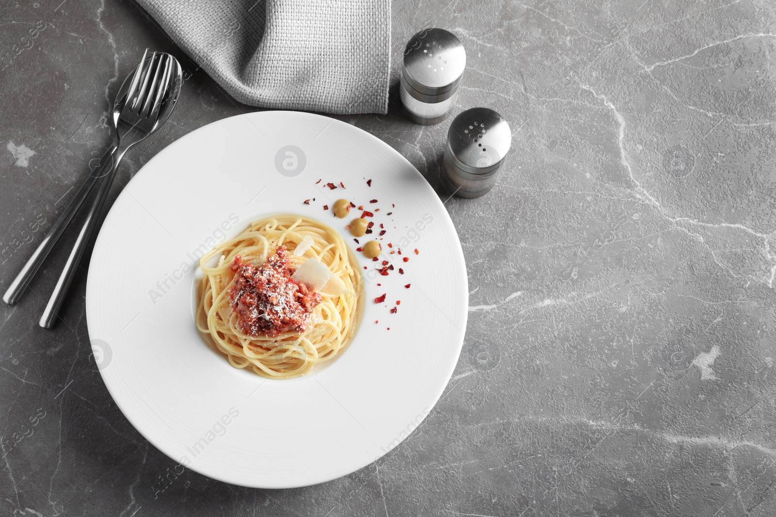 Photo of Plate with delicious pasta bolognese on grey background, top view