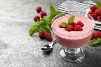 Photo of Delicious raspberry mousse with mint on grey table, space for text