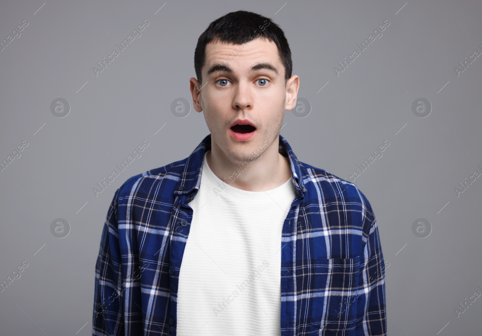 Photo of Portrait of surprised man on grey background