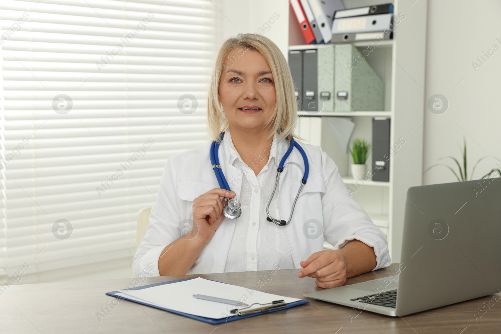 Photo of Doctor sitting at wooden table in clinic