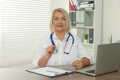 Doctor sitting at wooden table in clinic