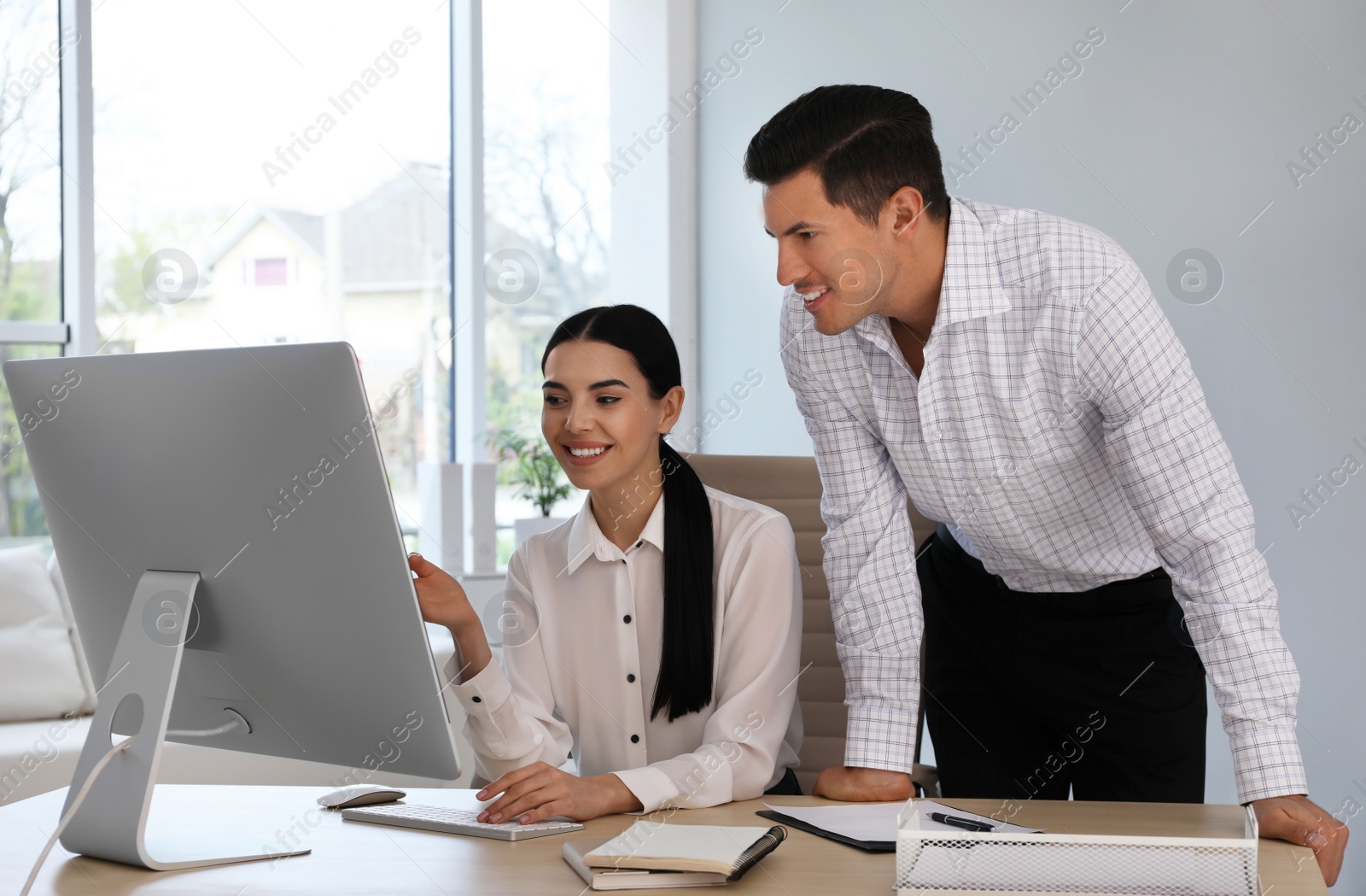 Photo of Man and his secretary working at table in office